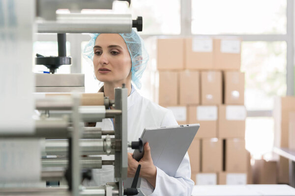 Female manufacturing supervisor checking equipment