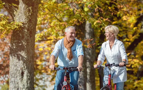 Seniorenpaar auf Fahrrädern unterwegs — Stockfoto