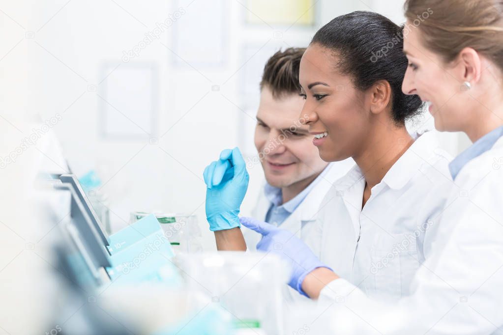 Group of researchers during work on devices in laboratory 