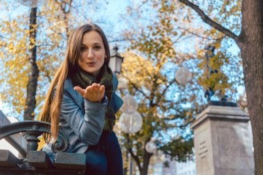 Kadın veren hava öpücük kamerasına sonbahar Park