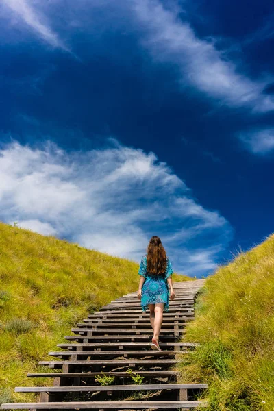 インドネシアの木製階段を上る若い女性の完全な長さ背面図 — ストック写真