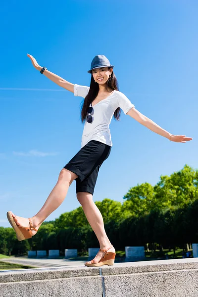 Asiatisk kvinna stående på ett ben utomhus — Stockfoto