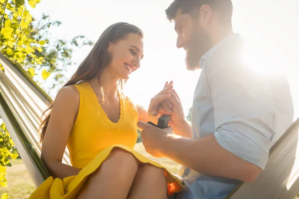 Felice uomo mettendo anello di fidanzamento al dito della ragazza su — Foto Stock