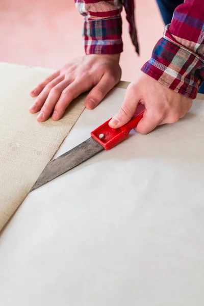 Primer plano de las manos de un hombre que corta una nueva hoja de papel pintado dur — Foto de Stock