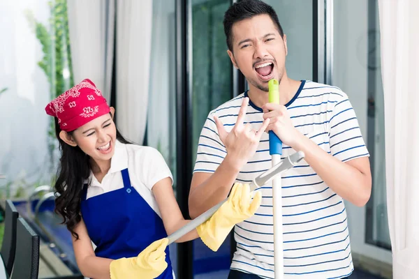 Indonesian couple having fun cleaning the home — Stock Photo, Image