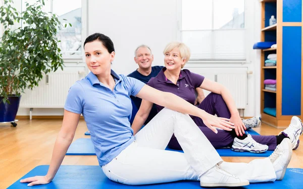 Fisio mostrando ejercicios de espalda a sus pacientes —  Fotos de Stock