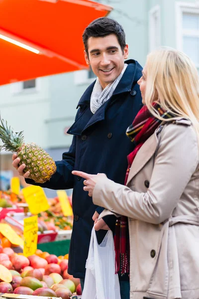Couple buying groceries on farmers market stand — Stock Photo, Image
