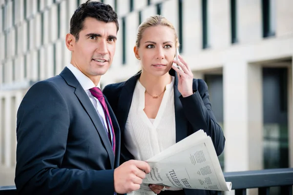Business man and woman with paper and phone — Stock Photo, Image