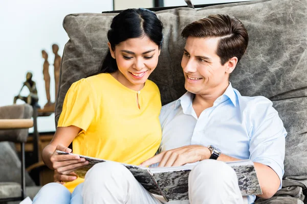 Couple sitting in chair of furniture store — Stock Photo, Image