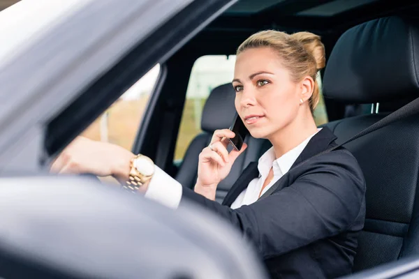 Frau benutzt ihr Handy während der Autofahrt — Stockfoto