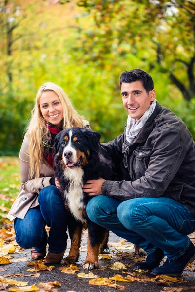 Paar mit Hund genießt Herbst in der Natur — Stockfoto