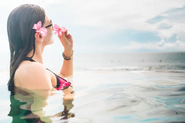 Vrouwelijke toerist in infinity zwembad van hotel resort — Stockfoto