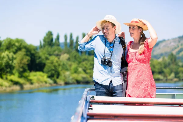 川の幸せなカップルが夏に着て太陽帽子をクルーズします。 — ストック写真
