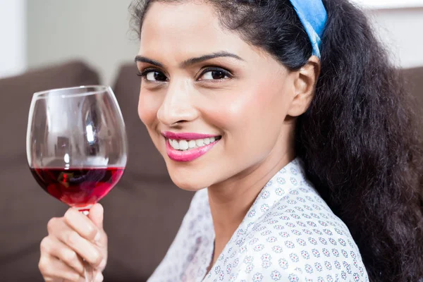 Bela jovem mulher bebendo vinho tinto em casa — Fotografia de Stock