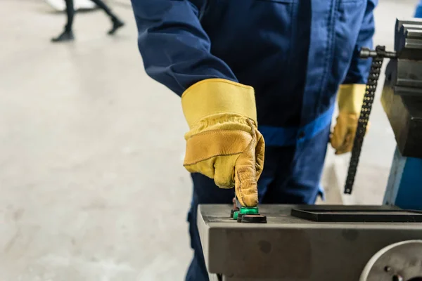 Hand van een werknemer die op de knop van een industriële machine — Stockfoto