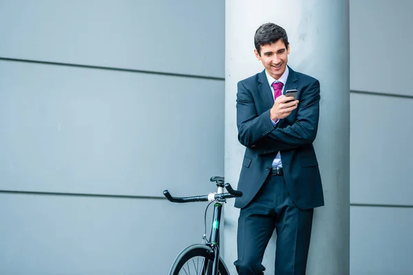 Jovem alegre se comunicando no telefone celular enquanto espera o — Fotografia de Stock