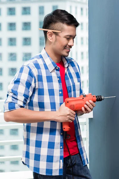 Asiatischer Heimwerker beim Bohren — Stockfoto