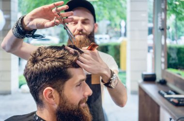 Ayrılmış kuaförü kullanarak makas ve bir coo verirken tarak