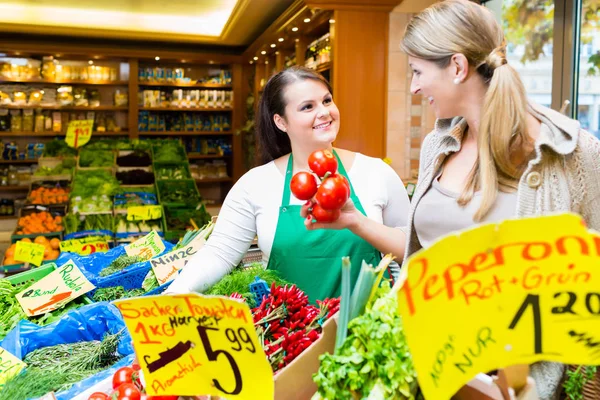 Verkoopster helpen vrouw boodschappen winkelen — Stockfoto