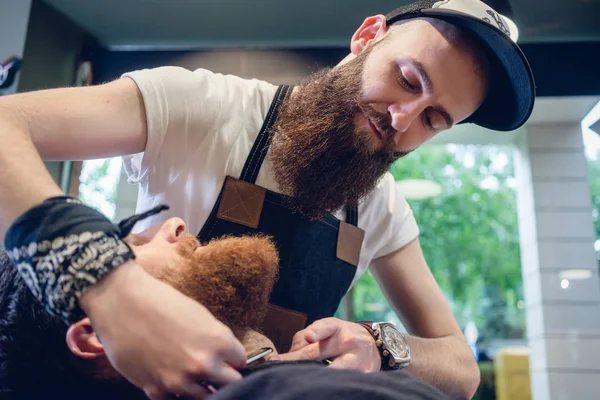 Jovem barbudo pronto para barbear-se no salão de cabeleireiro de uma habilidade — Fotografia de Stock