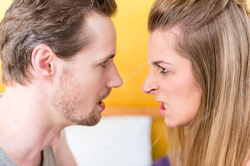 Young married couple, woman and man, in furious fight staring an
