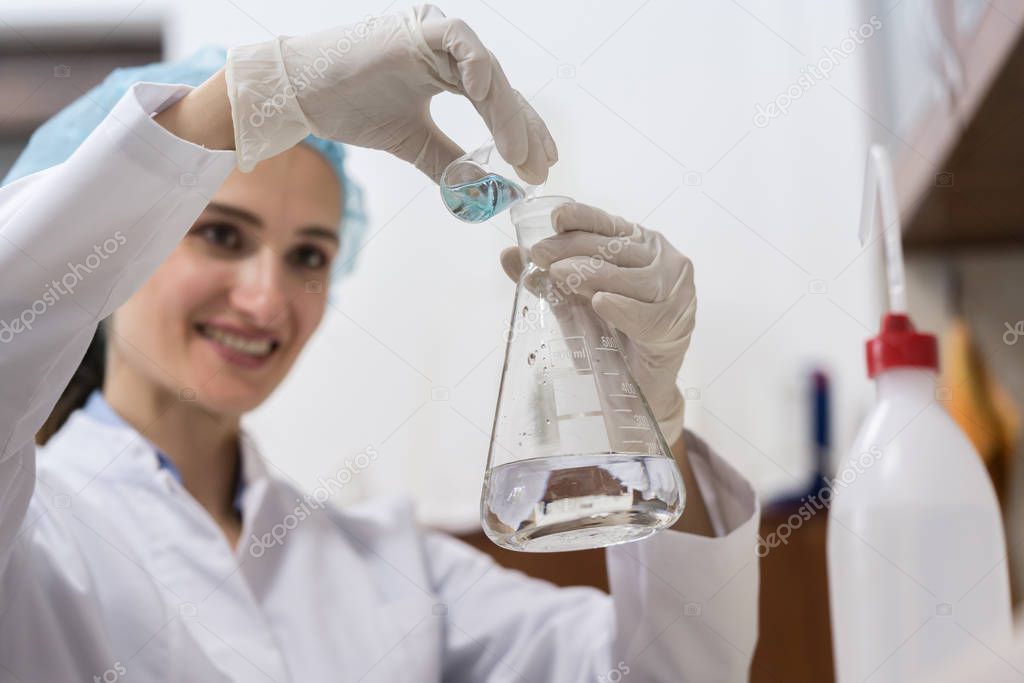 chemist mixing two liquid chemical substances during experiment