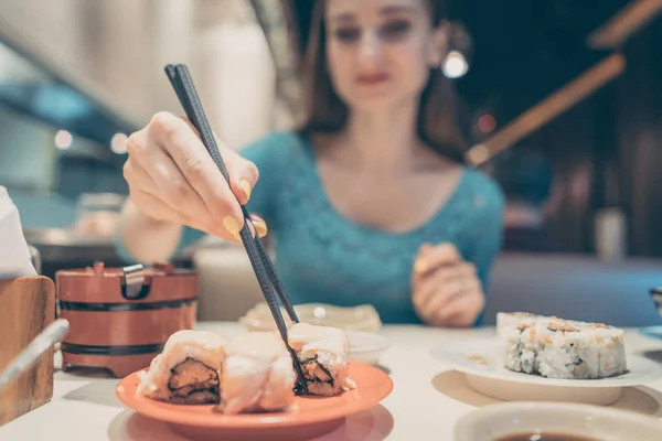 Femme mangeant des sushis au restaurant japonais — Photo