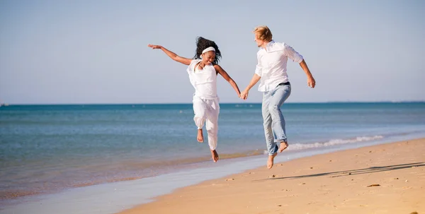 Пара в отпуске на пляже, черная женщина и белый мужчина — стоковое фото