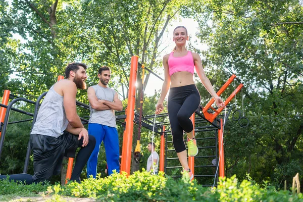 Hermosa mujer saltando cuerda en los aplausos de sus amigos dur — Foto de Stock