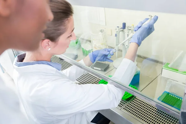 Grupo de científicos en laboratorio de investigación que trabajan bajo salpicadura — Foto de Stock