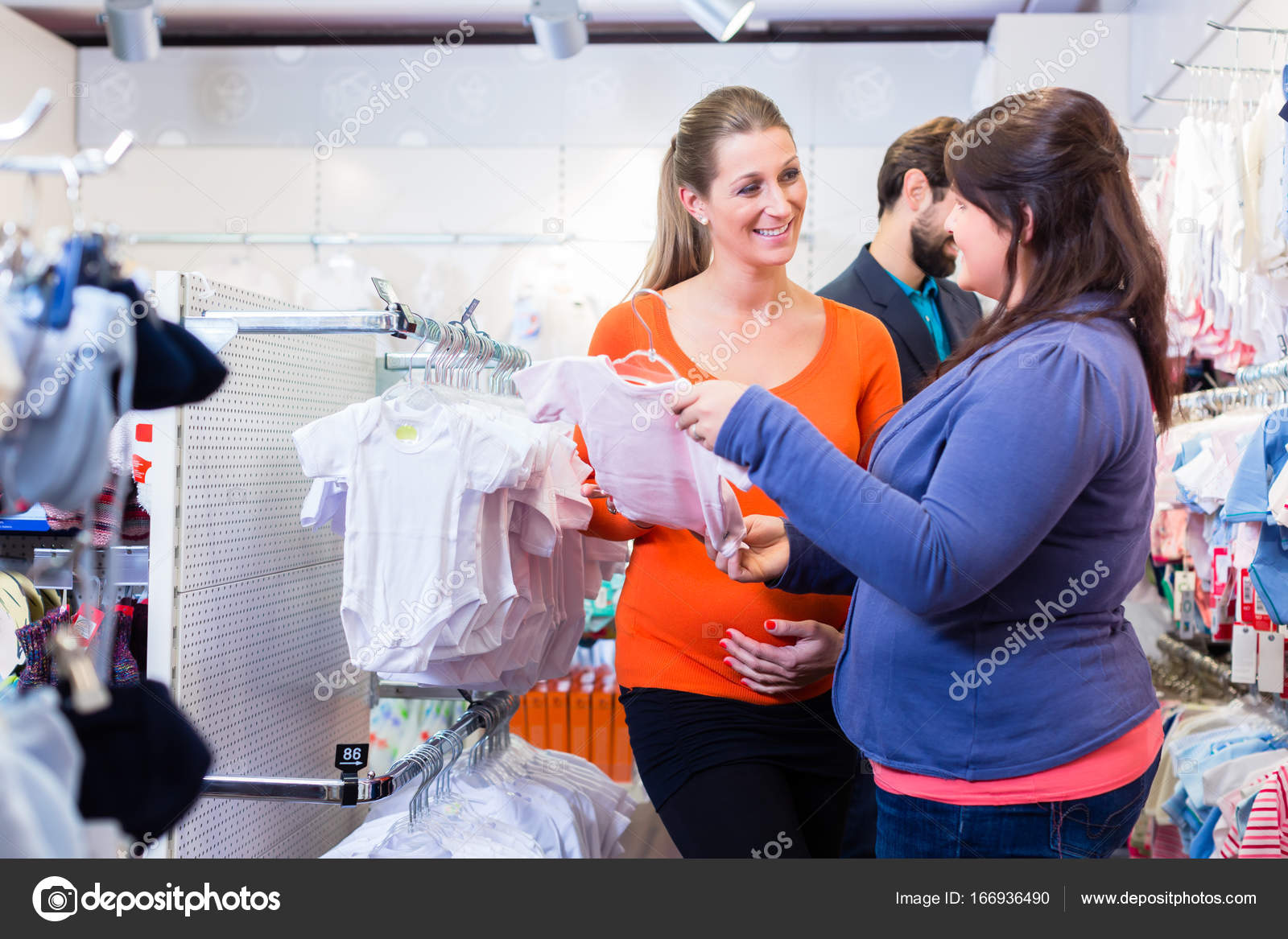 Vendedor con pareja comprando ropa de bebe en la tienda Foto de stock 166936490 Kzenon