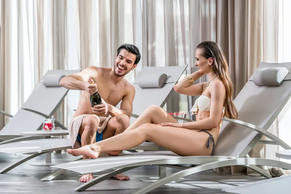 Young man opening bottle of champagne — Stock Photo, Image