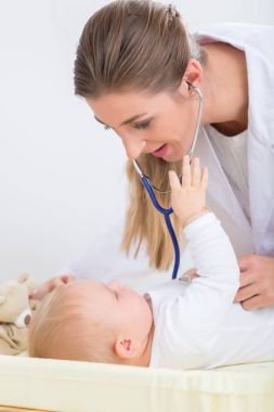 kadın çocuk doktoru stetoskop kullanarak