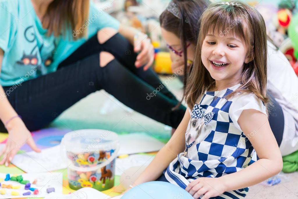 Cheerful girl playing on floor