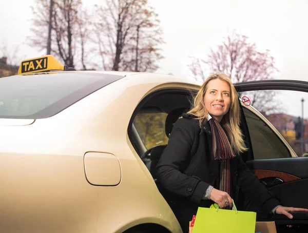 Young woman gets out of taxi — Stock Photo, Image