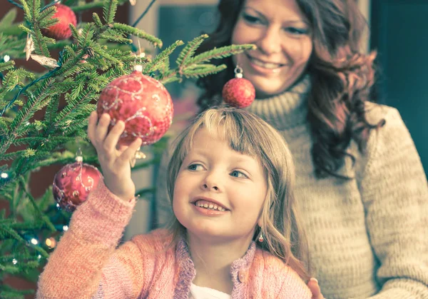 Flickan håller några julgranskulor — Stockfoto