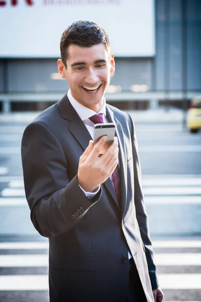 Obchodní muž dívá na smartphone — Stock fotografie