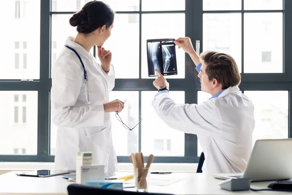Experienced orthopedist helping colleague — Stock Photo, Image