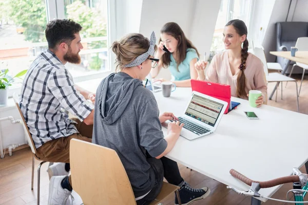 Hängiven ung kvinna redigerar ett dokument i en modern office spac — Stockfoto