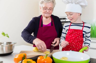Granny cooking together with her grandson clipart
