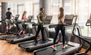 Fitness salonunda koşu bandı üzerinde çalışan dört kişilik grup