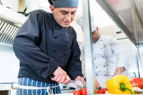 Cocineros cocinando y cortando verduras y tomates —  Fotos de Stock