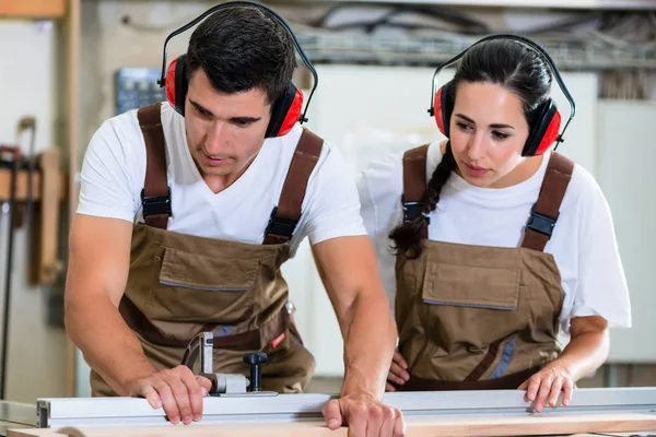 Плотник и ученик работают вместе в мастерской — стоковое фото
