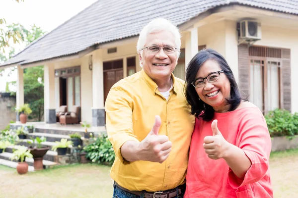 Nöjd äldre par visar tummen framför sin nya res — Stockfoto