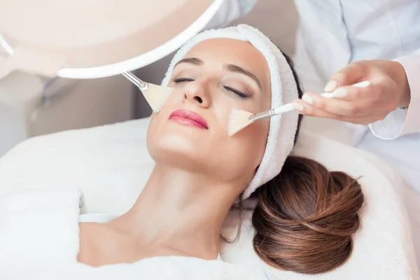 Hermosa mujer durante el masaje facial anti-envejecimiento en un moderno cos —  Fotos de Stock