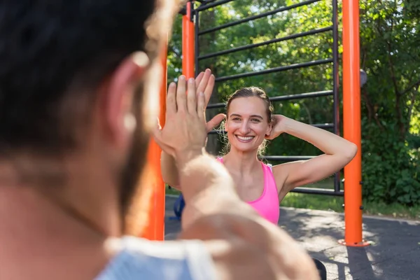 Jovem alegre dando high-five para seu parceiro enquanto faz — Fotografia de Stock