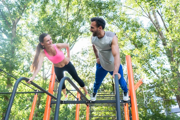 Mladá fit žena i její partner praktikování cvičení prkno — Stock fotografie