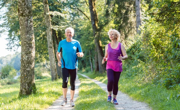 Due anziani attivi facendo jogging insieme — Foto Stock