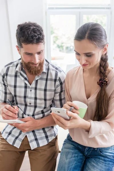 Due giovani lavoratori che guardano il telefono — Foto Stock