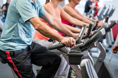 Spor salonunda fitness bisiklet üzerinde grup iplik
